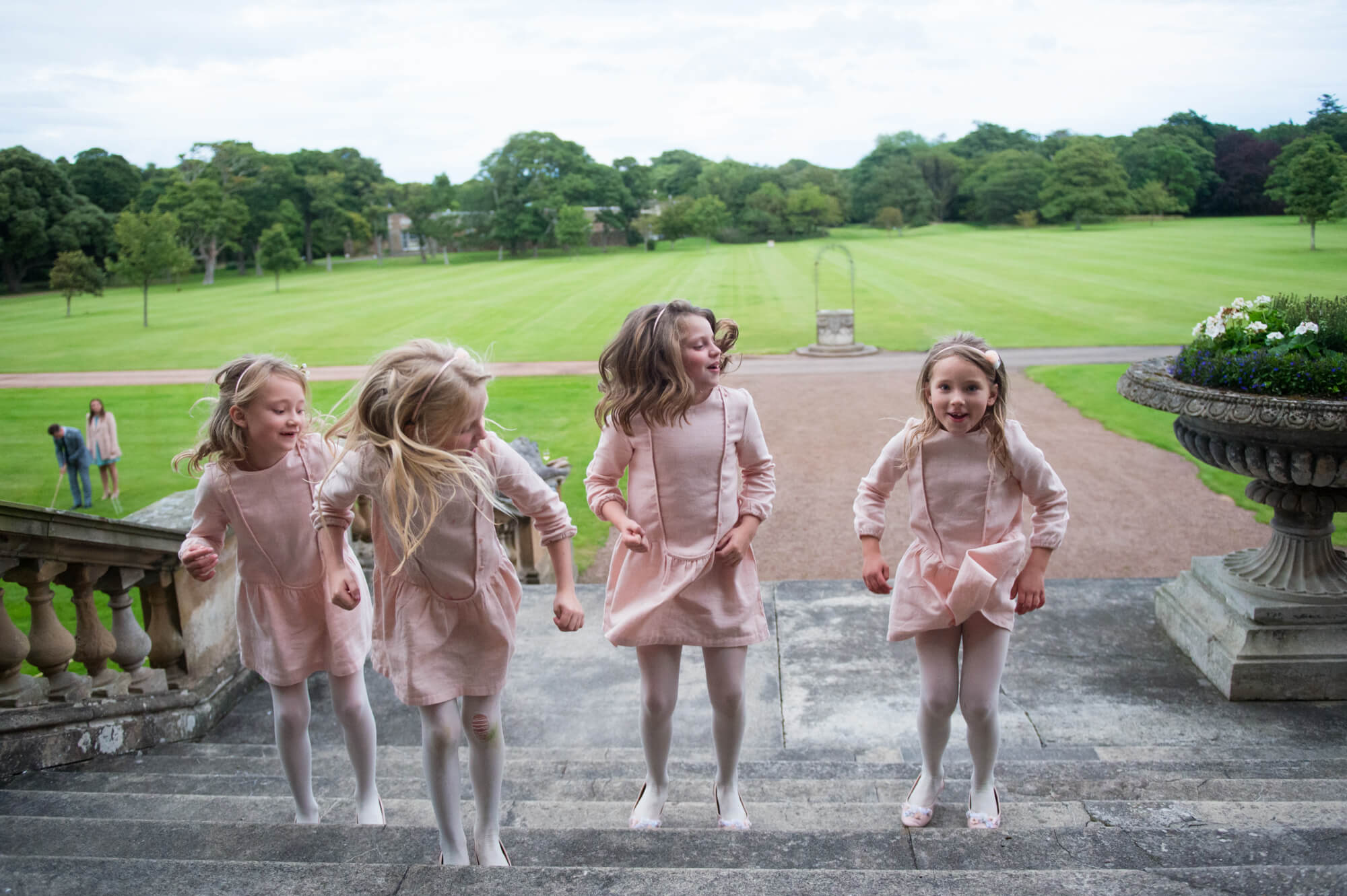 Flower girls jumping down the steps at Gosford House